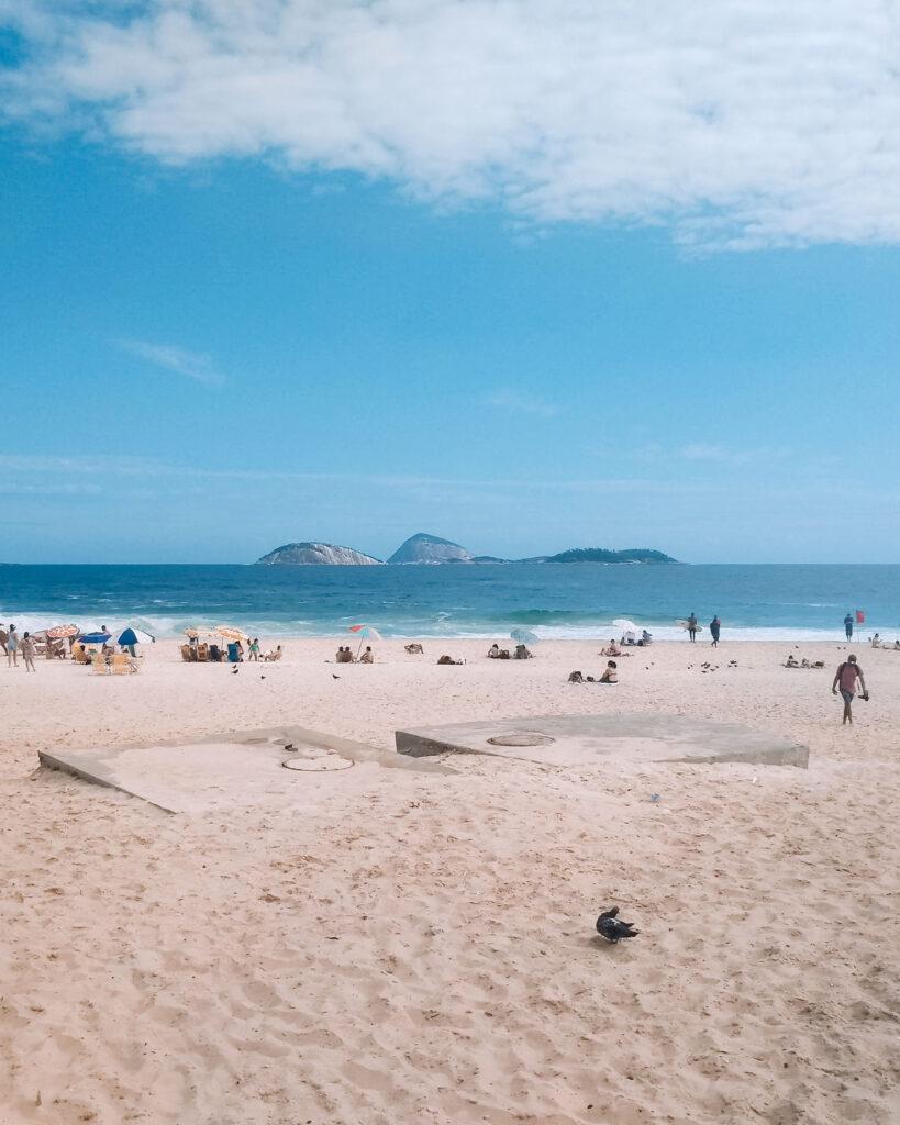 El hermoso paisaje de la Playa de Ipanema en un día soleado, con sus arenas doradas y el cielo fundiéndose con el mar.